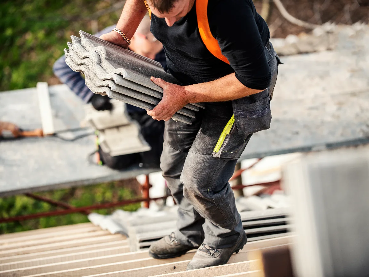 Roofer carrying tiles